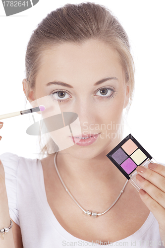 Image of young beautiful woman applying eyeshadow on eyes