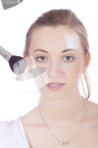 Image of young beautiful woman applying mineral powder 