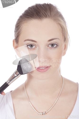 Image of young beautiful woman applying mineral powder 