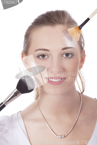 Image of young beautiful woman applying mineral powder 