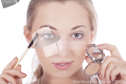 Image of young beautiful woman applying eyeshadow on eyes