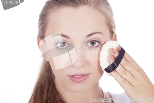 Image of young beautiful woman applying mineral powder 