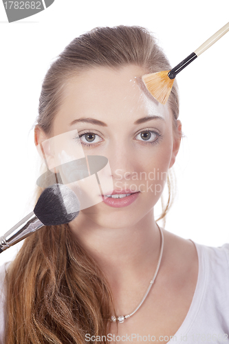 Image of young beautiful woman applying mineral powder 