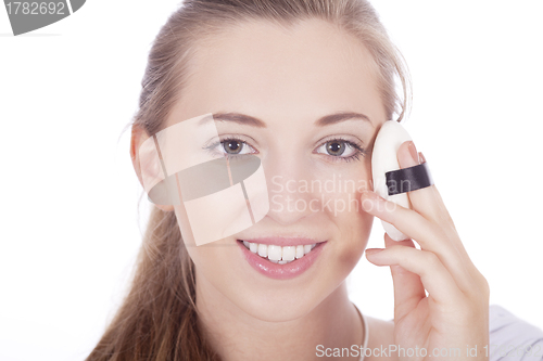 Image of young beautiful woman applying mineral powder 