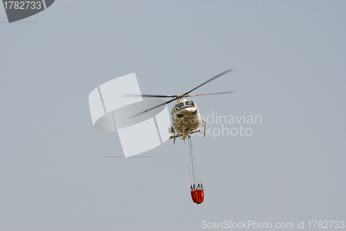 Image of Firefighter helicopter carrying a water bucket