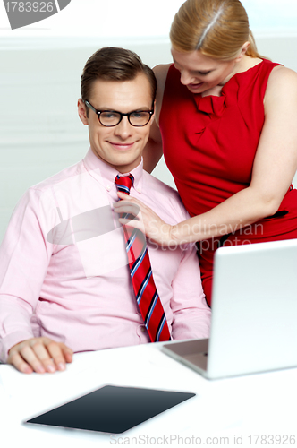 Image of Female adjusting her co-workers tie