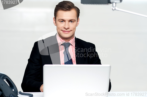 Image of Handsome young businessman with laptop