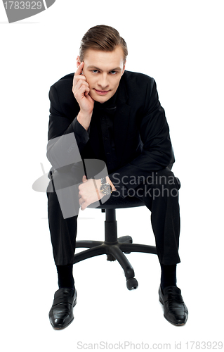 Image of Handsome young caucasian male sitting on chair