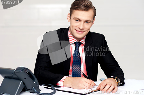 Image of Handsome young man making notes