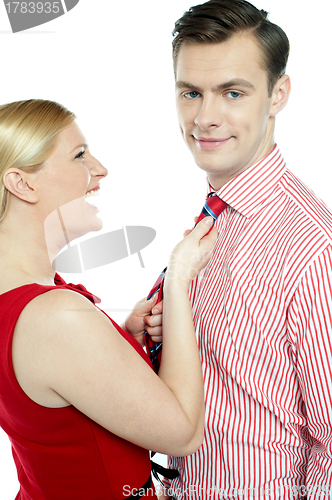 Image of Glamorous woman pulling man by his tie