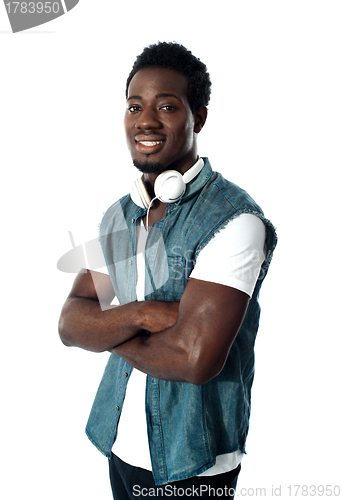 Image of Man standing with headphones around his neck