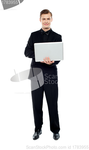 Image of Smiling young man working on laptop
