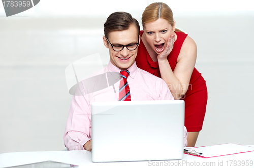 Image of Shocked woman looking into laptop. Man working