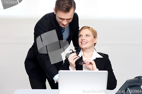 Image of Business people at work. Male pointing at laptop
