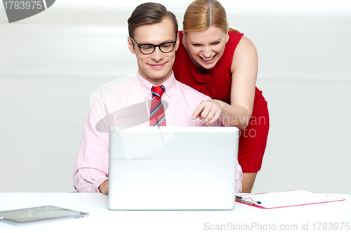 Image of Lady pointing at something funny in laptop