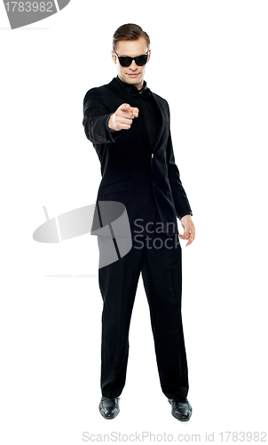 Image of Man in party wear attire pointing at camera