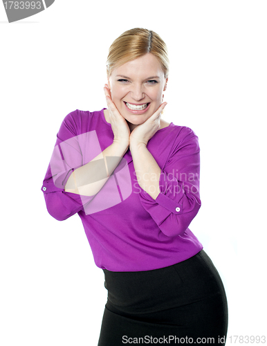 Image of Excited woman posing with hands on chin