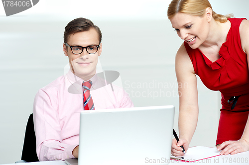 Image of Woman writing information from laptop