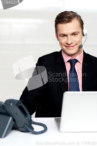 Image of Male executive wearing headsets and smiling