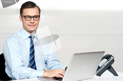 Image of Handsome corporate male tying on laptop