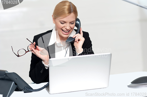 Image of Woman talking on phone holding eye glasses