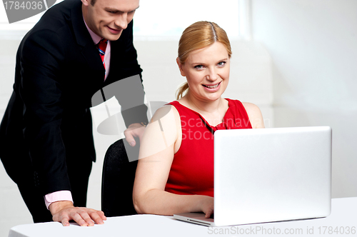 Image of Trendy female boss working with man assisting