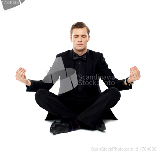 Image of Smart young man in party wear doing yoga