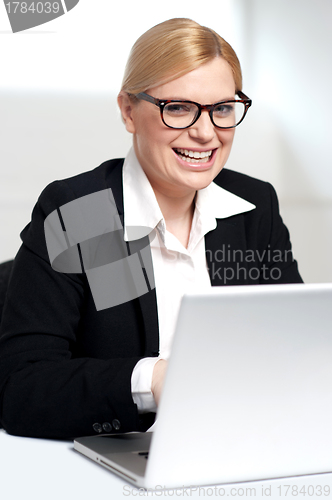 Image of Smiling young female executive at work desk