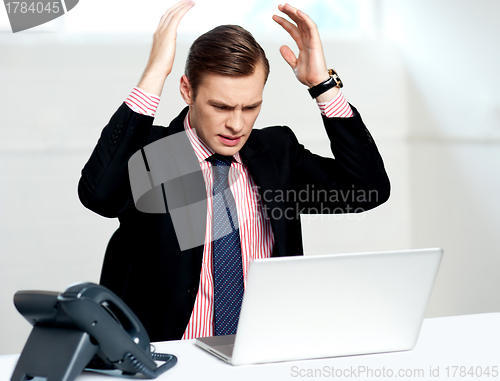 Image of Disappointed businessman looking at laptop