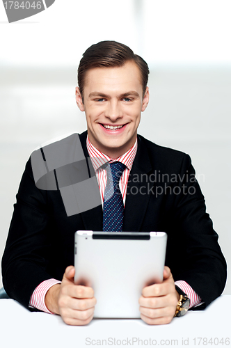 Image of Cheerful male executive holding digital device