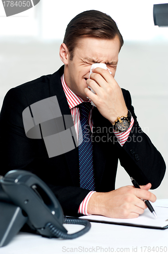 Image of Young man having severe cold. Sneezing