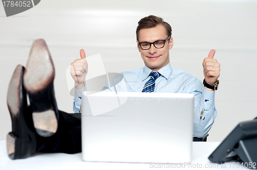 Image of Relaxed businessman gesturing thumbs up