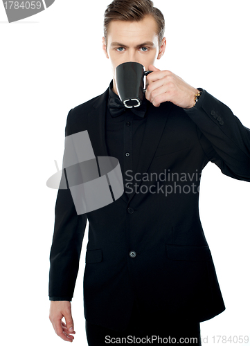Image of Smart young man drinking coffee in black cup