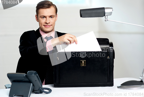 Image of Male executive keeping documents safely