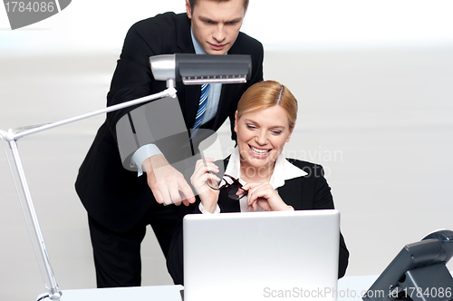Image of Man pointing finger at laptop screen