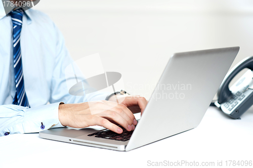 Image of Closeup shot of man working on a laptop