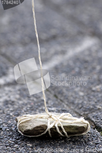 Image of stone weight on a rope