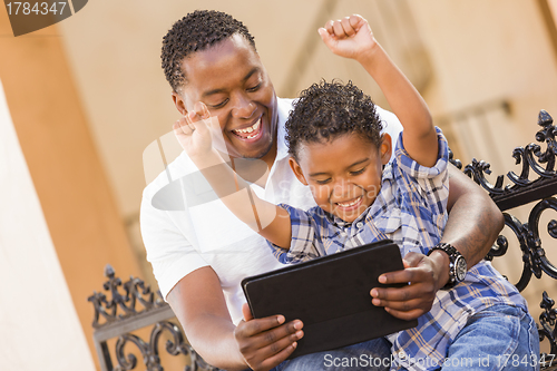 Image of Mixed Race Father and Son Using Touch Pad Computer Tablet