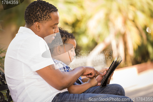 Image of Mixed Race Father and Son Using Touch Pad Computer Tablet