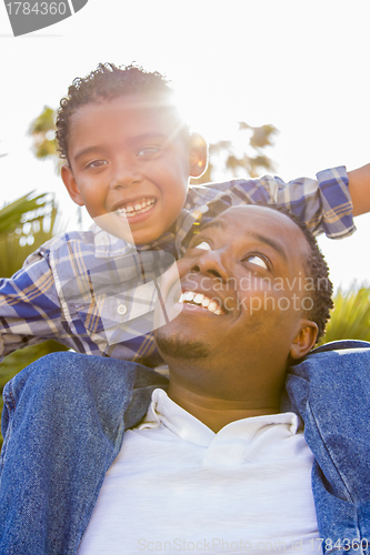 Image of Mixed Race Father and Son Playing Piggyback