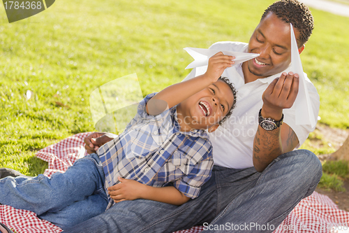 Image of Mixed Race Father and Son Playing with Paper Airplanes