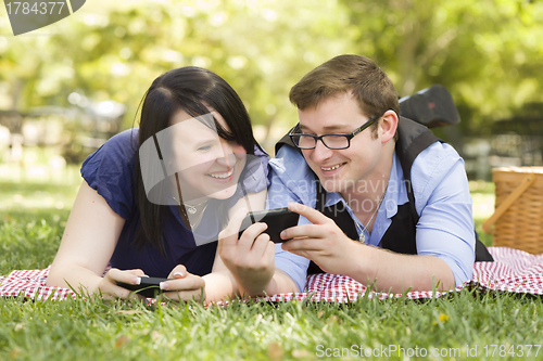 Image of Young Couple at Park Texting Together