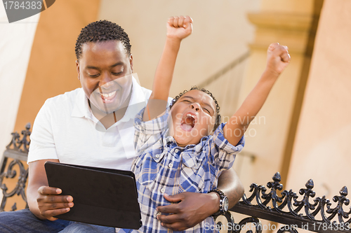 Image of Mixed Race Father and Son Using Touch Pad Computer Tablet