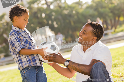 Image of Father Hands New Soccer Ball to Mixed Race Son