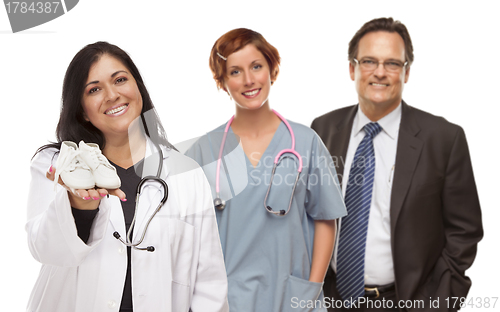 Image of Hispanic Female Doctor or Nurse with Baby Shoes and Support Staf