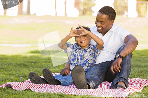 Image of Mixed Race Father and Son Making Heart Hand Sign