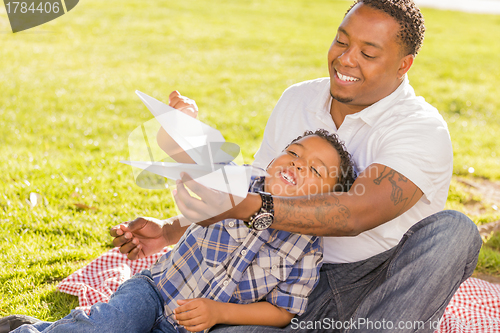 Image of Mixed Race Father and Son Playing with Paper Airplanes