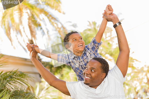 Image of Mixed Race Father and Son Playing Piggyback