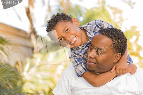 Image of Mixed Race Father and Son Playing Piggyback