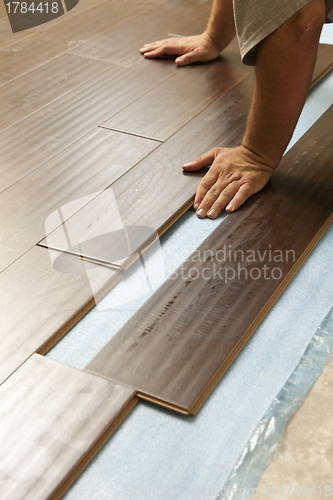 Image of Man Installing New Laminate Wood Flooring